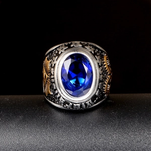 Macro detail of men's vintage stainless steel ring with blue oval gemstone and eye motif