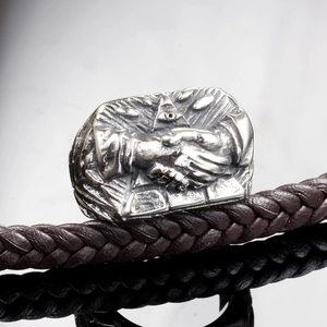 Gros plan d'une bague en acier vintage avec l'œil de la providence et relief main