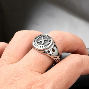 Detailed close-up of retro silver stainless steel ring with X pattern and punk engravings