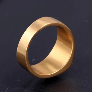 Vue macro d'une bague large en acier titane doré avec une texture en métal brossé fin