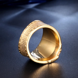 Macro shot of gold-plated wide ring showing intricate woven mesh texture and mirror polish