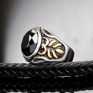Detailed side view of vintage men's ring with black gemstone and gold Om symbol