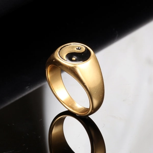Macro detail of gold stainless steel ring with yin yang tai chi enamel design
