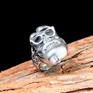 Close-up of vintage silver skull ring with glasses and detailed beard engraving