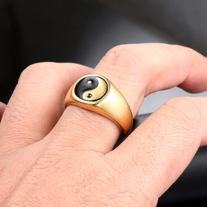Macro shot of gold stainless steel signet ring featuring black Tai Chi Yin Yang symbol