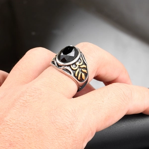 Close-up of vintage men's silver ring with large black gemstone and gold accents