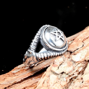 Vue macro d'une bague pentagramme argentée vintage avec bords texturés sur du bois