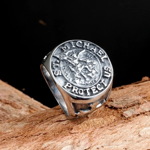 Macro shot of St. Michael Protect Us vintage stainless steel signet ring on wood