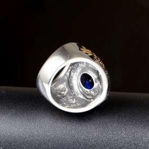 Men's stainless steel ring featuring oval blue gemstone and vintage engraved silver band