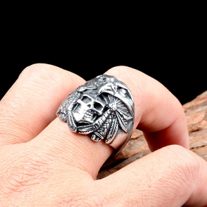 Detailed macro of vintage skull ring featuring intricate eagle feather headdress and engraving