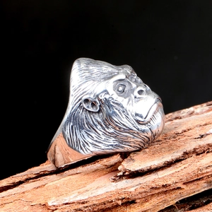 Gothic punk style gorilla head skull ring in silver metal for men on wood background