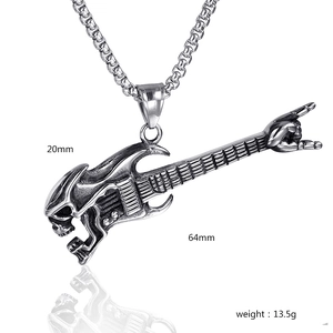 Macro detail of gothic guitar pendant with skull and rock hand gesture in stainless steel