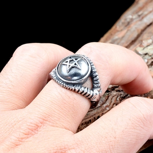 Gros plan d'une bague vintage en acier inoxydable avec pentagramme et anneau gravé
