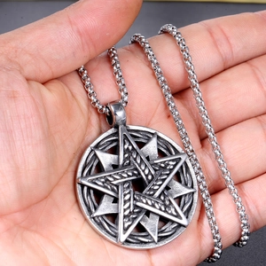 Détail macro d'un pendentif étoile en acier inoxydable avec texture vintage à la main
