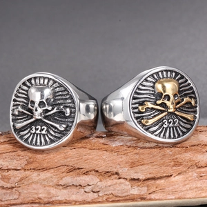Macro shot of punk style stainless steel skull rings with number 322 on tree bark