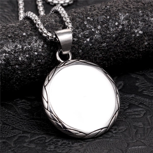 Macro d'un pendentif circulaire poli argenté avec bordure texturée et chaîne box