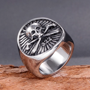 Vintage stainless steel pirate skull ring with 322 engraving on textured wood base