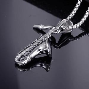 Polished stainless steel saxophone pendant necklace on a reflective black surface