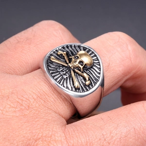 Detailed view of skull and crossbones signet ring with gold relief on a male hand