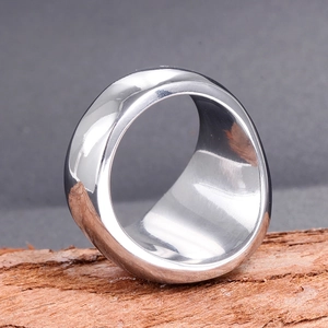 Macro shot of a thick polished stainless steel ring on a natural rustic wood bark