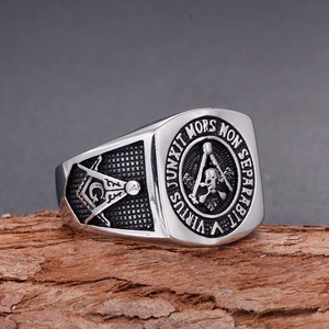 Macro detail of Freemason ring with skull and Latin motto on vintage wood block