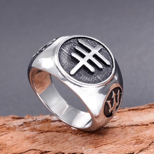 Vintage stainless steel signet ring for men featuring an engraved trident on rustic wood