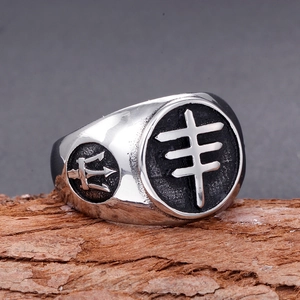 Vintage stainless steel signet ring for men with cross and trident motifs on wood
