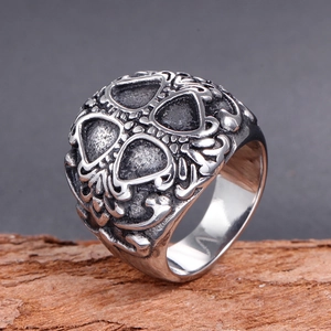 Macro detail of gothic stainless steel ring with vintage finish on a wood block