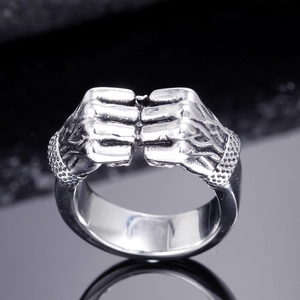Nahaufnahme eines Vintage-Edelstahlrings mit detailliertem Doppelfaust-Design