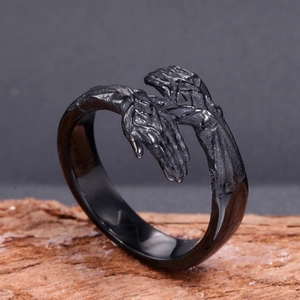Macro shot of black stainless steel gothic open ring with detailed hand bone carvings