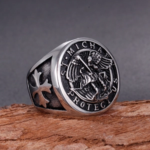 Macro view of St. Michael stainless steel seal ring with side cross relief on wood