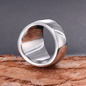Polished stainless steel wide band ring for men with mirror finish on rustic wood