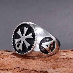 Dettaglio macro di anello a croce vintage in acciaio inossidabile con rilievo nero