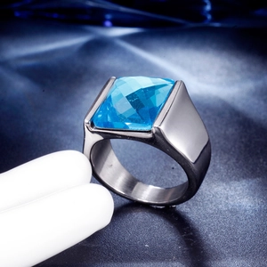 Macro detail of men's stainless steel ring featuring a square cut blue gemstone inlay
