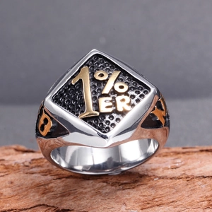Macro detail of bicolour stainless steel 1% ER biker ring on rustic wood surface