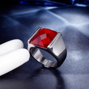 Macro shot of men's stainless steel ring with a faceted rectangle red gemstone