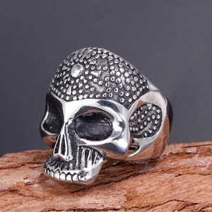 Gothic punk style skull ring in vintage stainless steel on rustic wood background