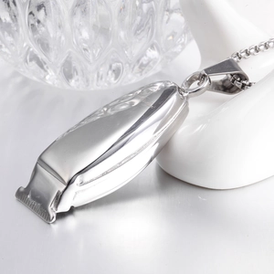 Vue macro d'un collier pendentif rasoir argenté montrant les détails en acier poli