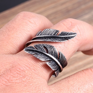 Detailed macro view of vintage stainless steel double feather ring on a male finger