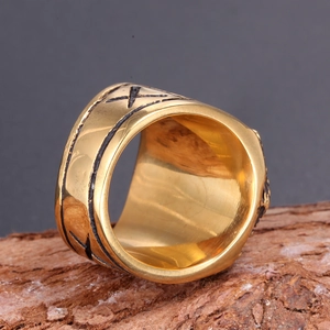 Anello Martello di Thor vintage dorato con rune nordiche su sfondo di legno rustico