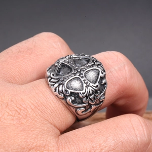 Macro shot of vintage stainless steel ring with gothic relief pattern on hand