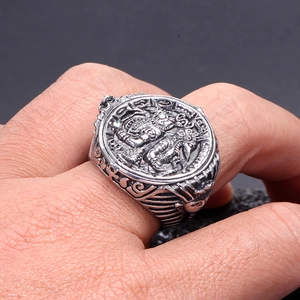Macro view of vintage stainless steel pharaoh ring with circular relief pattern on hand