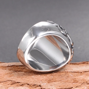 Macro view of wide vintage silver skull ring with detailed side reliefs and metal shine