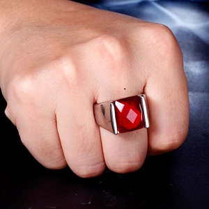 Macro detail of men's stainless steel ring featuring a large square red garnet gemstone