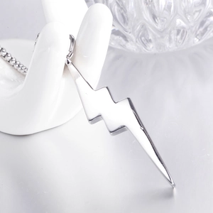 Polished stainless steel lightning bolt pendant necklace on elegant hand display stand