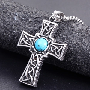Vintage titanium steel celtic cross necklace with blue stone on dark rock background