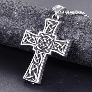 Retro stainless steel Celtic cross pendant with intricate knotwork on stone display