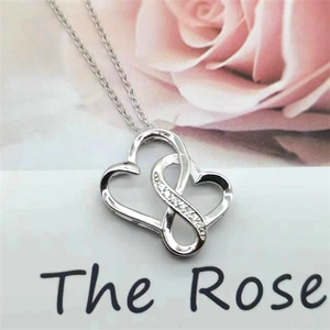 Close-up of double heart pendant necklace with shimmering zircon stones on a chain