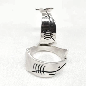 Dettaglio di anelli regolabili in argento sterling S925 con incisione minimalista a lisca di squalo