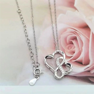 Macro view of S925 sterling silver interlocking double heart pendant with fine diamond accents